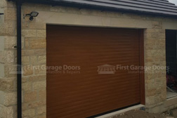 Golden oak roller garage door on a new build garage